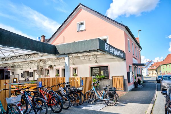 Blick auf ein lachsfarbenes Haus mit überdachten Vorhof.