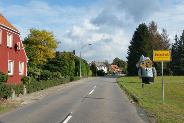 Ortseingang von Soltendieck mit Ortsschild und Strohfigur.