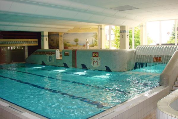 Das Schwimmbecken des Hallenbades "Römerlagune". Die Wände sind mit verschiedenen Motiven und Bildern dekoriert.