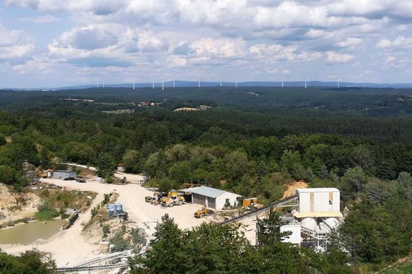 Blick auf das Betriebsgelände des Steinbruchs mit Häuschen und Maschinen.
