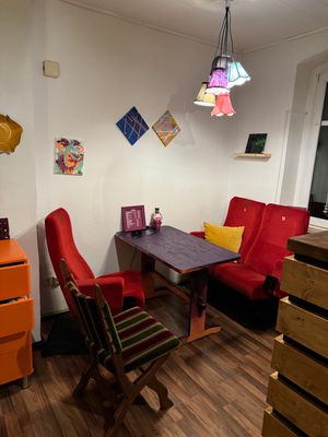 Auf dem Bild ist der Innenraum mit Sitzgelegenheiten im TinteBarKunst zu sehen.
