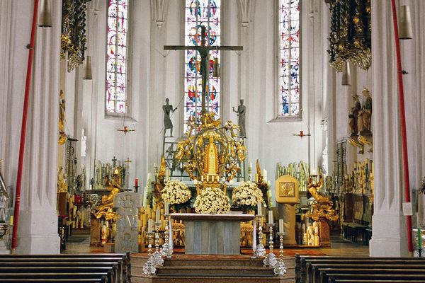 Vor dem eindrucksvollen Altarraum der Wallfahrtskirche Bogenberg ragen links und rechts zwei hohe Pfingstkerzen bis zur Kirchendecke empor.