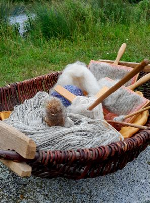 Ein Korb mit Wolle und Stricknadeln.