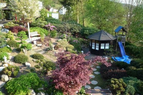 Kleines Gartenhaus mit Kinderrutsche und Sandkasten