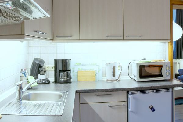 Küchenzeile mit Spüle, Kaffeemaschine, Wasserkocher und Mikrowelle