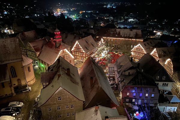Der Blick geht über die Altstadt von Schlitz, deren letze Häuser im Dunkel der Nacht am Horizont verwschwinden. Der Marktplatz ist hell erleuchtet. Viele Buden und Lichterketten an den umliegenden Fachwerkhäusern zaubern in der verschneiten Innenstadt eine heimelige, vorweihnachtliche Stimmung.