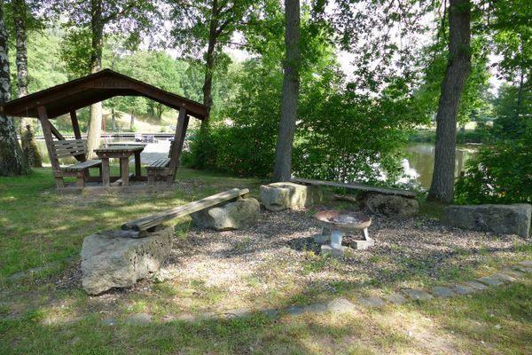 Lagefeuerstelle im Strandbad Dorfmark im Hintergrund eine Überdachte Sitzmöglichkeit
