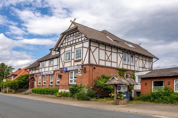 Gebäude mit Holzstruktur aus seitlicher Perspektive mit Gehweg und Bepflanzung