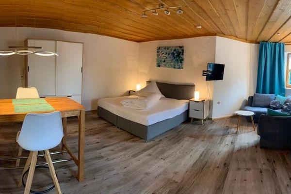 Blick in das Appartement mit Bett und Sitzgelegenheit