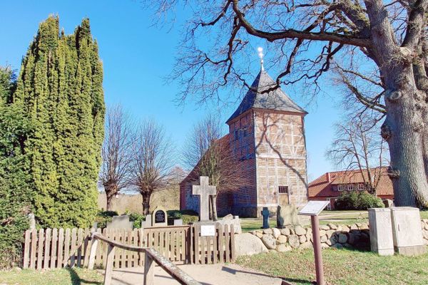 Die St.-Georgs-Kirche in Wichmannsburg, eine historische Feldsteinkirche aus dem 10. Jahrhundert, mit ihrem charakteristischen Fachwerkturm und dem gotischen Altarretabel.