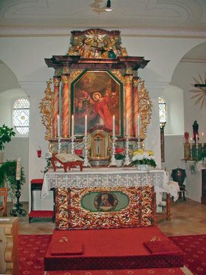 Der Altar der St. Stephanus-Kirche in Konzell ist mit brennenden Kerzen und Blumen dekoriert.