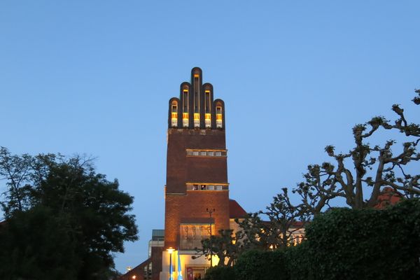Die beleuchtete Hochzeitsturm mit dunkelblauem Himmel in der Dämmerung. Die Spitze des Turms hat die Form von fünf Fingern einer ausgestreckten Hand. Die fünf Fenster in der Tumspitze sind hell erleuchtet.