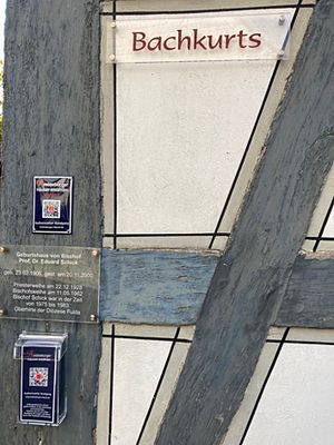 Ein historisches Haus in Amöneburg mit einem dunkelblauen Schild und QR-Code ist zu sehen.