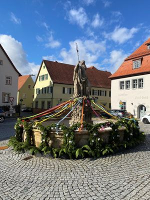Mit begrünten Bögen, bunten Bändern und bemalten Ostereiern geschmückter Neptunbrunnen auf dem Marktplatz von Thurnau