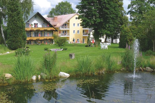 Hausansicht mit Teich und Garten