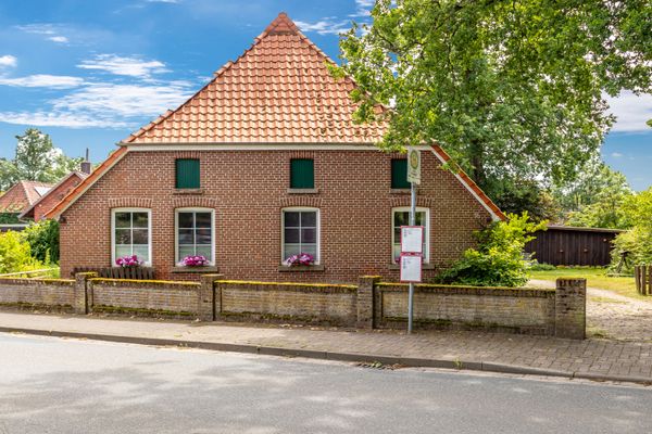 Backsteinhaus mit Zaun an einer Straße