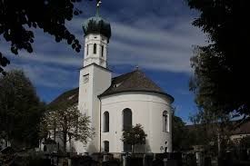 Der Betrachter blickt auf eine große barocke Kirche mit Zwiebelkirchturm.