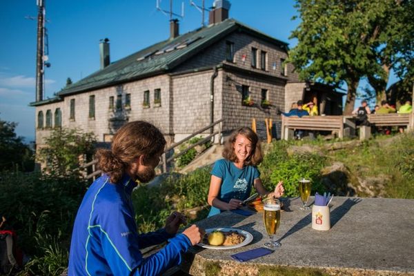 Gäste, die vor der Gaststätte sitzen und etwas essen und trinken