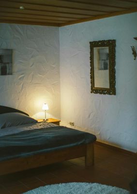 Holzbett mit Teppich und stimmungsvollem Licht