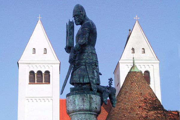 Welfenstatue mit dem Welfenmünster im Hintergrund