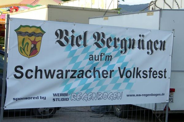 Am Eingang des Volksfestes steht eine Werbeplane. Hier werden die Besucherinnen und Besucher mit den Worten "Viel Vergnügen auf´m Schwarzacher Volksfest" begrüßt.