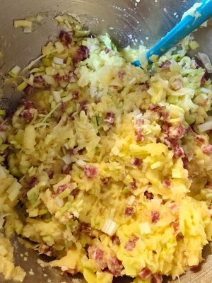 Das Gericht mit Zwiebel-Speck-Sauce liegt auf einem hellblauen Teller in Nahaufnahme vor dem Betrachter.
