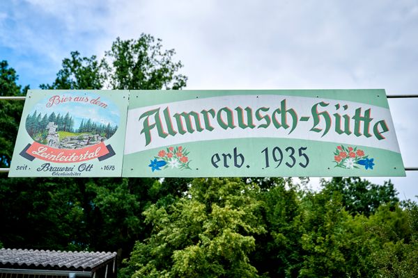 Blick auf ein Schild über dem Eingang mit Aufschrift Almrausch-Hütte.
