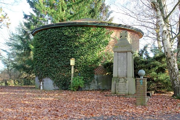 Ein ehemaliger, runder Wasserturm mit Steinbank in einem Park – Standort der „Privatsammlung Dreyer“ in Himbergen