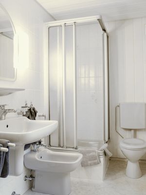 Badezimmer mit Dusche, Waschbecken, Bidet und WC in weißer Ausstattung.