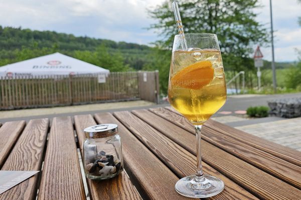 Getränk mit Glas-Strohalm in einen hohen Glas auf einem Holztisch