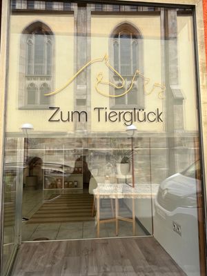 Auf dem Bild ist das Logo von Zum Tierglück auf der Eingangstür zu sehen.