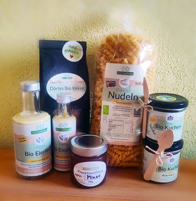 Ein Sortiment von Produkten des Hofladens. Zu lesen ist auf den Packungen, Gläsern und Flaschen folgendes: Bio Eierlikör, Dörtes Bio Kekse, Bio Eier Nudeln, Fruchtaufstrich Apfel-Minze, Bio Kuchen im Glas mit Eierlikör.