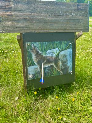 Eine Zielscheibe aus Holz, auf welchem ein heulender Wolf zu sehen ist