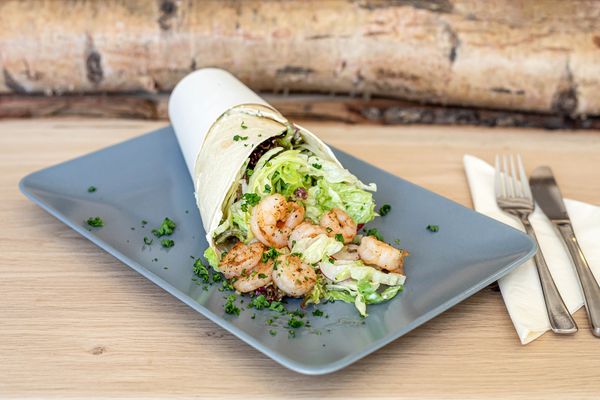 Wrap mit Hähnchenfleisch und Salat auf einem Teller