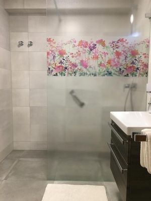 Badezimmer mit ebenerdiger Dusche und WC