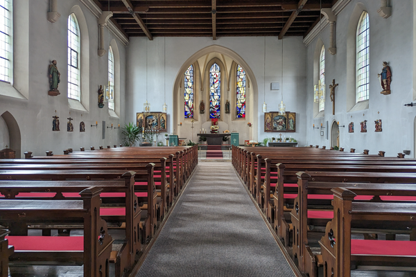 Das Bild zeigt den Innenraum der St. Pankratius Kirche in Steinberg. Man sieht auf der linken und rechten Seite Sitzbänke, einen Altar, Gemälde und Statuen.