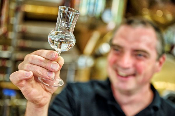 In der Brennerei Haas steht der Inhaber Johannes Haas und schwenkt ein Glas mit Schnaps.