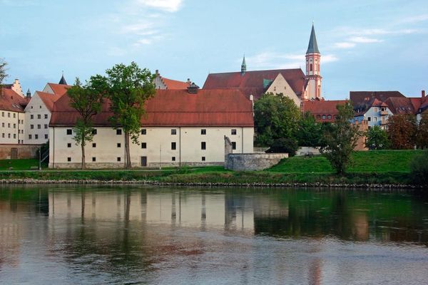 Im Vordergrund fließt die Donau. Dahinter stehen der Salzstadel, das Herzogschloss, die Karmelitenkirche und weitere Gebäude in enger Nachbarschaft.