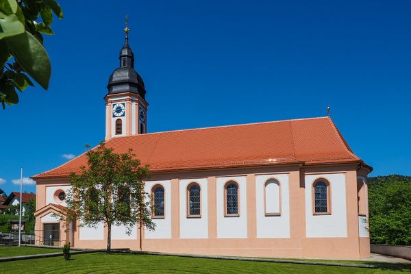 Pfarrkirche Neukirchen unter strahlend blauem Himmel.