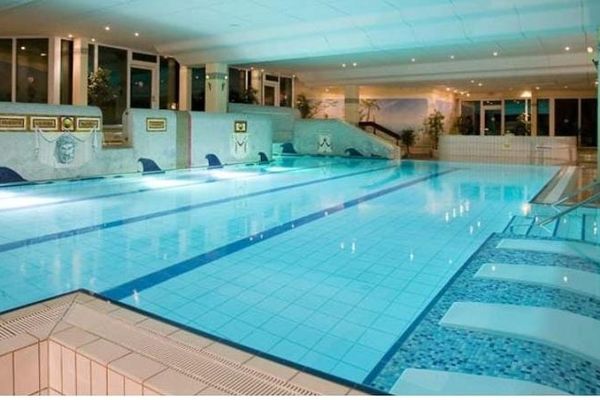 Hallenbad Römerlagune mit Liegebecken und beleuchtetem Schwimmbecken.