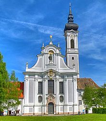 Der Betrachter blickt direkt auf das Eingangsportal des barocken Marienmünsters mit dem hohen Kirchturm.