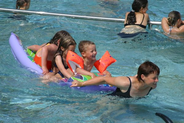 Auf dem Bild sind mehrere Personen (Kinder) im Schwimmbecken zu sehen.