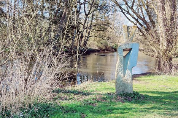 Die Skulptur „Flusswächterin“ von Gisela Milse steht direkt am Ufer der Ilmenau in Bienenbüttel. Sie zeigt eine aufrechte, archaische Frauengestalt mit einer Öffnung im Herzbereich, durch die der Fluss sichtbar ist – als Symbol für das freie Fließen von Energie. Die Figur beobachtet aufmerksam ihre Umgebung, richtet den Blick auf den Weg und den Fluss. Die umgebende, weich geglättete Fläche deutet Wasser, Bewegung und Umhüllung zugleich an.