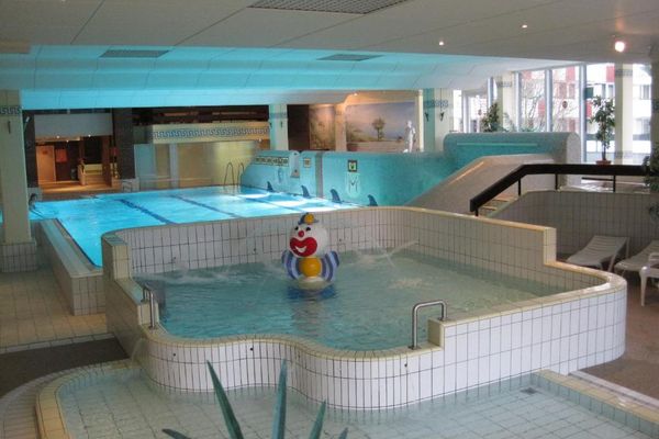 Das Hallenbad "Römerlagune". Im Vordergrund das Kinderbecken mit Clownfigur, im Hintergrund das Hauptschwimmbecken. Die Wände sind mit verschiedenen Motiven und Bildern dekoriert.