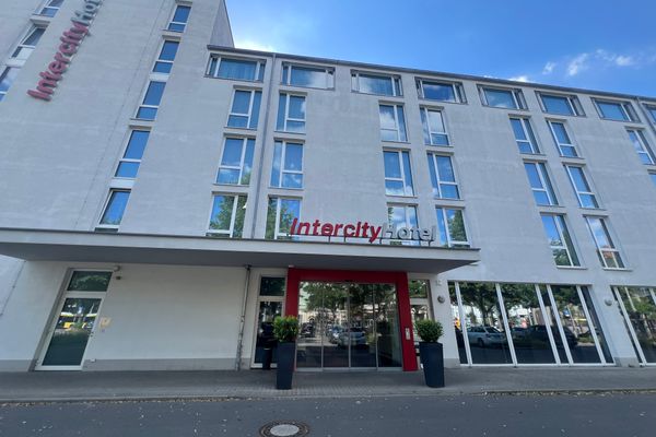 Fassade des mehrstöckigen Intercity-Hotels mit großem Schriftzug und Glas-Eingangstür unter blauem Himmel