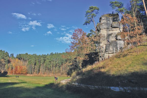In einem Tal erhebt sich seitlich eine Felswand.