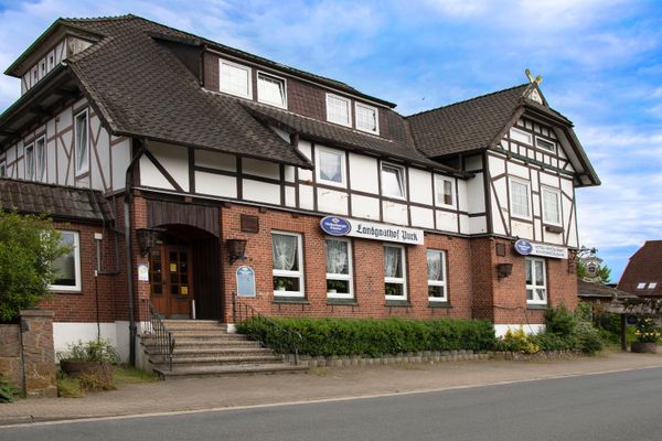 Gebäude mit Holzstruktur, Eingangstreppe und Fenstern entlang einer Straße