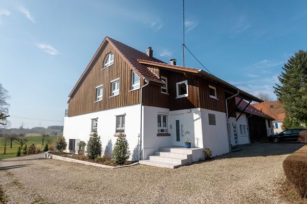 Außenansicht Ferienwohnung Bergfeld mit blauem Himmel und Wiese im Hintergrund