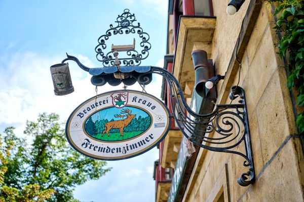 Blick auf das Schild an der Fassade einer Gaststätte.