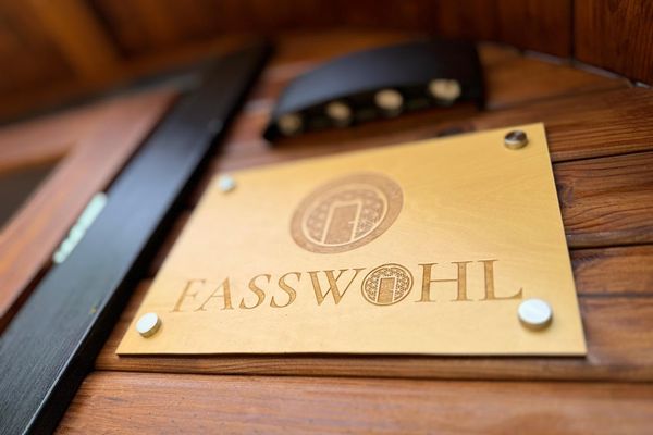 Auf dem Bild ist ein Schild mit dem Logo von FASSWOHL zu sehen.